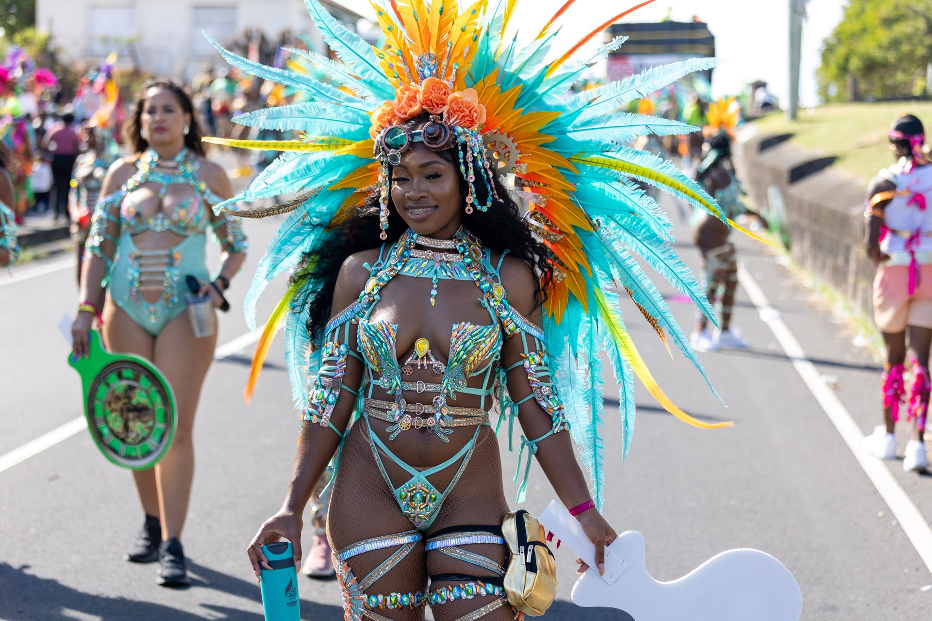 Masquerader in a turquoise feathered costume on a carnival parade road in St Kitts